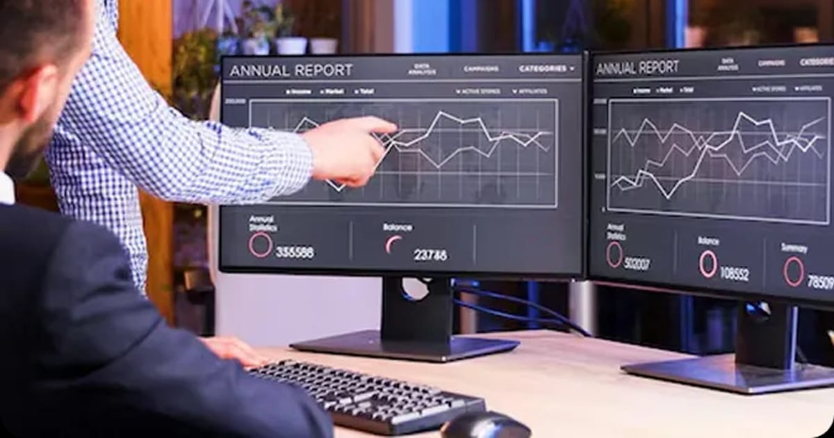 Team reviewing business intelligence charts on monitors
