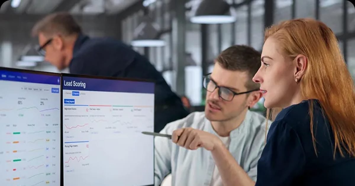 Sales team reviewing CRM pipeline data on monitors